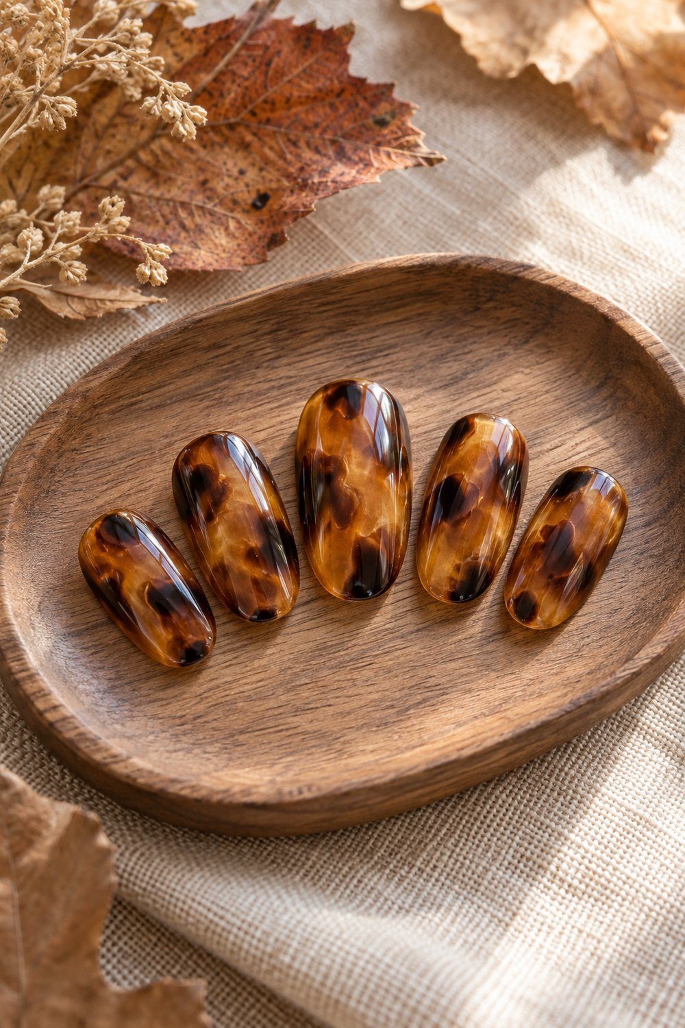 Translucent amber oval nail tips with layered brown tortoiseshell patches