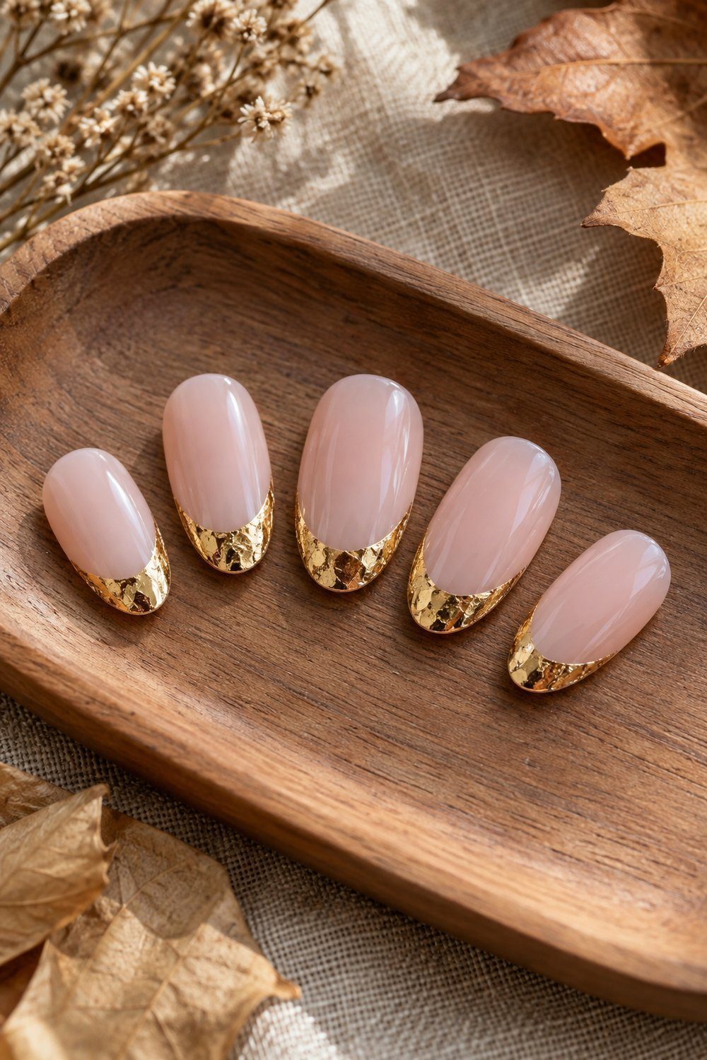 Neutral pink oval nail tips finished with crisp gold foil edges