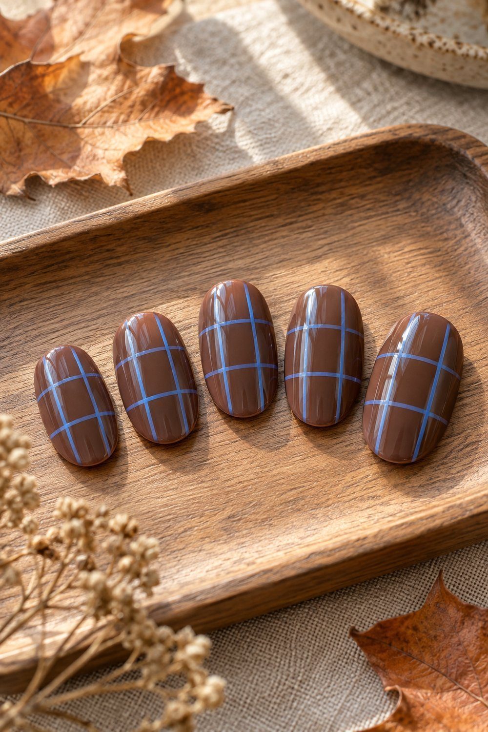 Mocha oval nail tips crossed with fine blue and black plaid